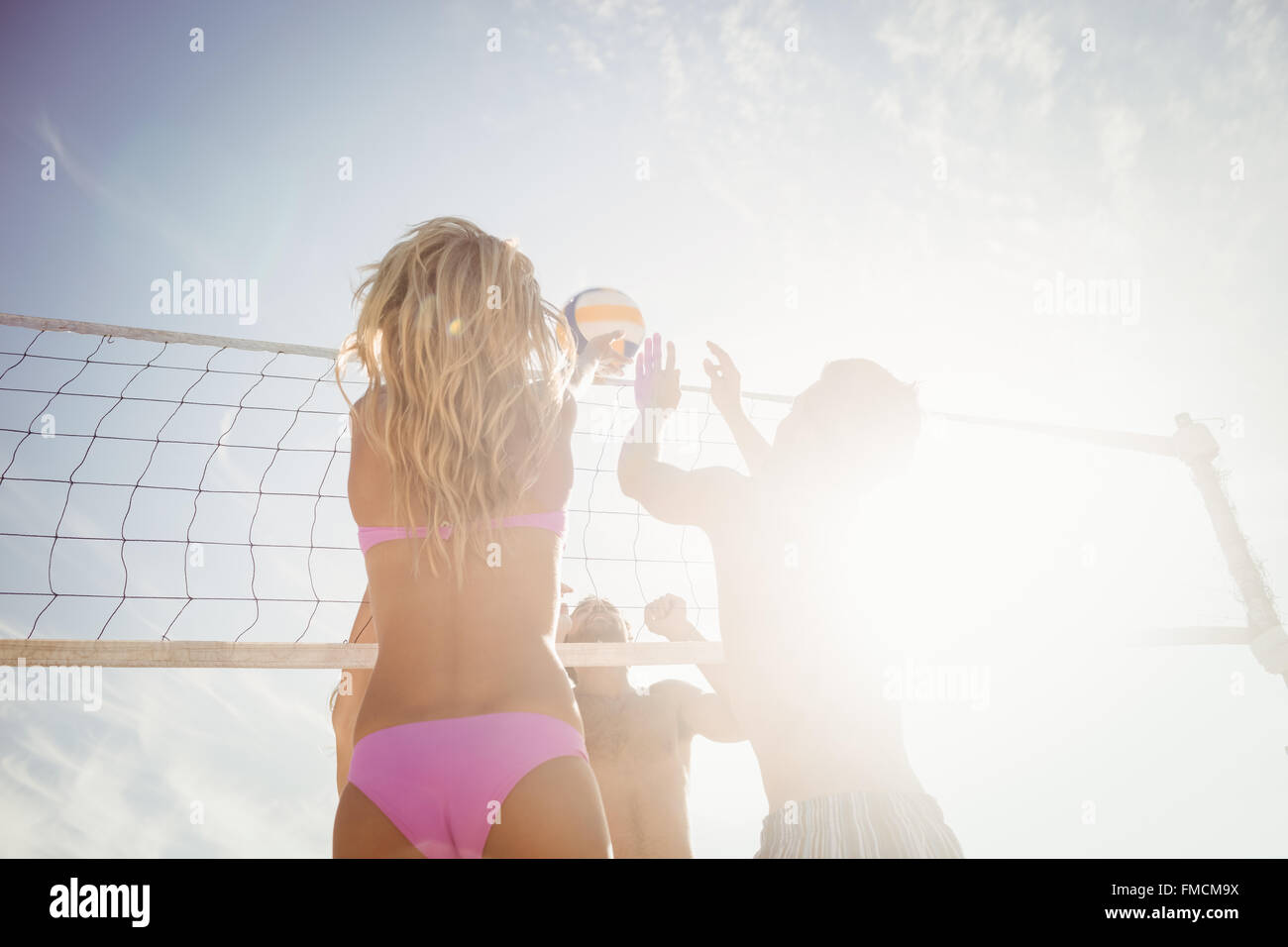 Friends playing beach volleyball Stock Photo