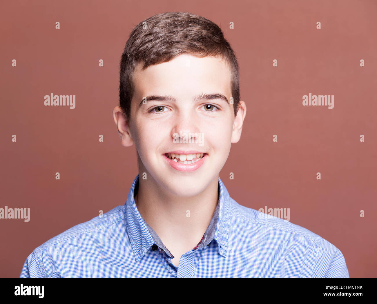 Photo of a smiling boy looking at camera on brown background Stock ...