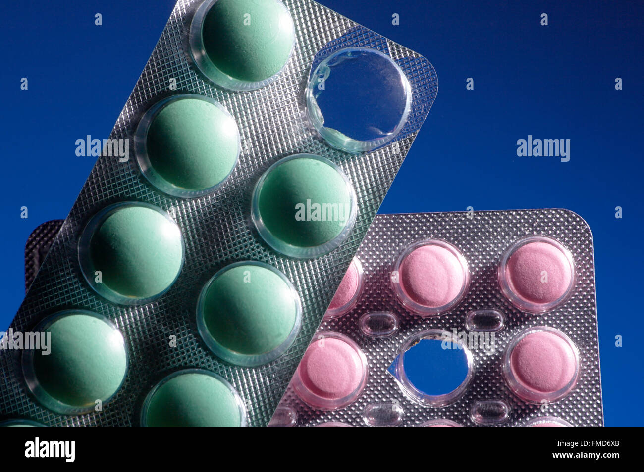 Pink and green tablets on a dark blue background Stock Photo