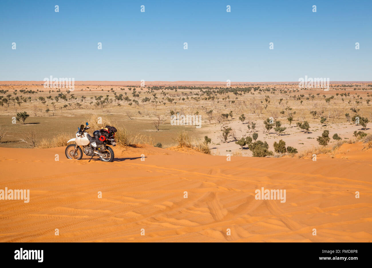 an adventurous motorcyclist reaches the 'Big Red', the last big Simpson Desert sand dune on the Way to Birdsville, Central West Stock Photo