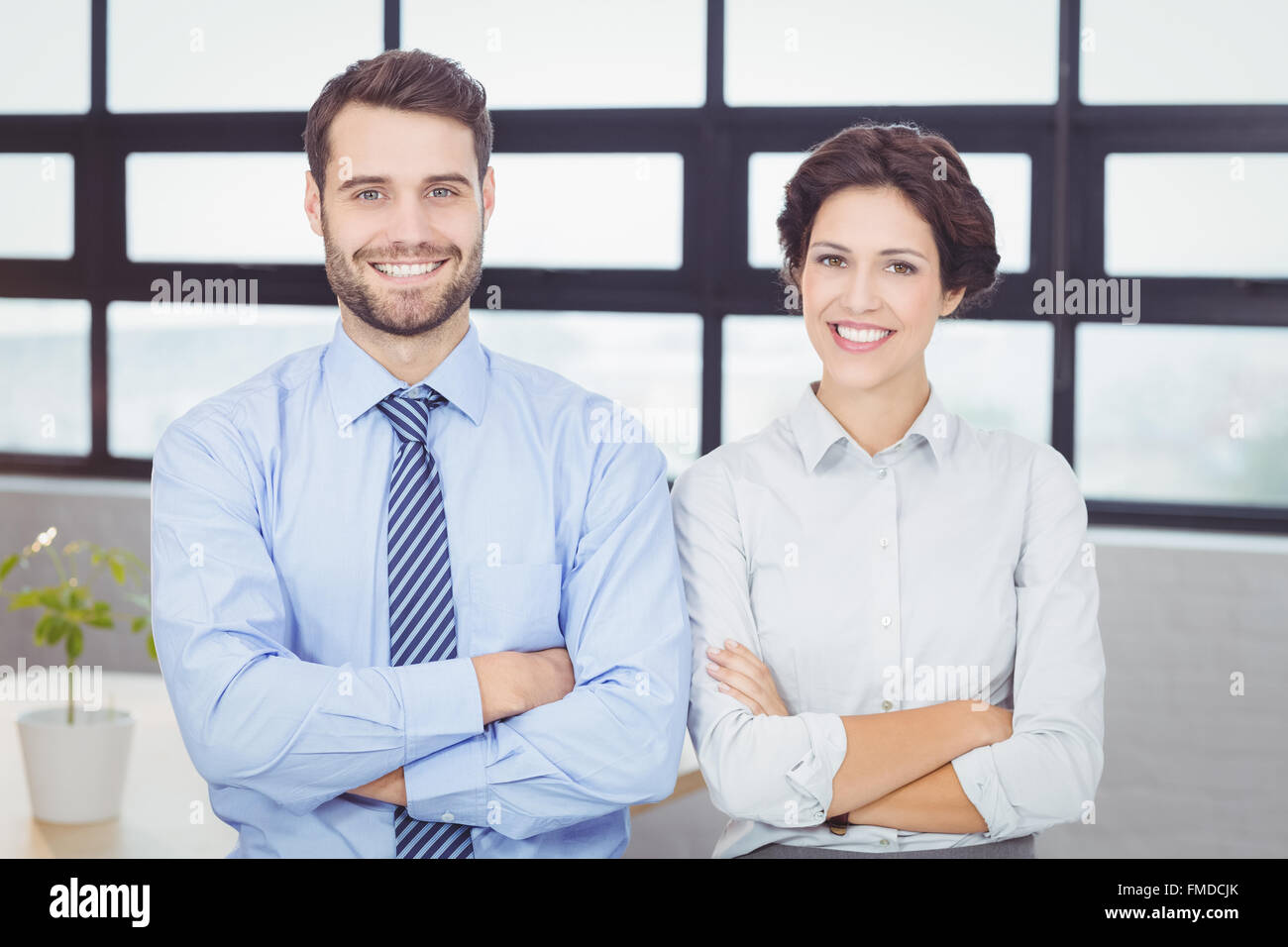 Happy business people with arms crossed in office Stock Photo - Alamy