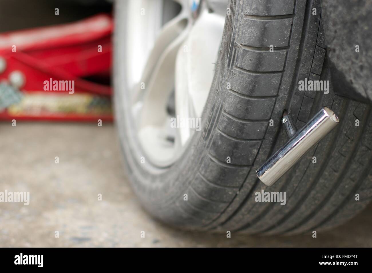 Fix the tire coz of Nail in car tire Stock Photo Alamy