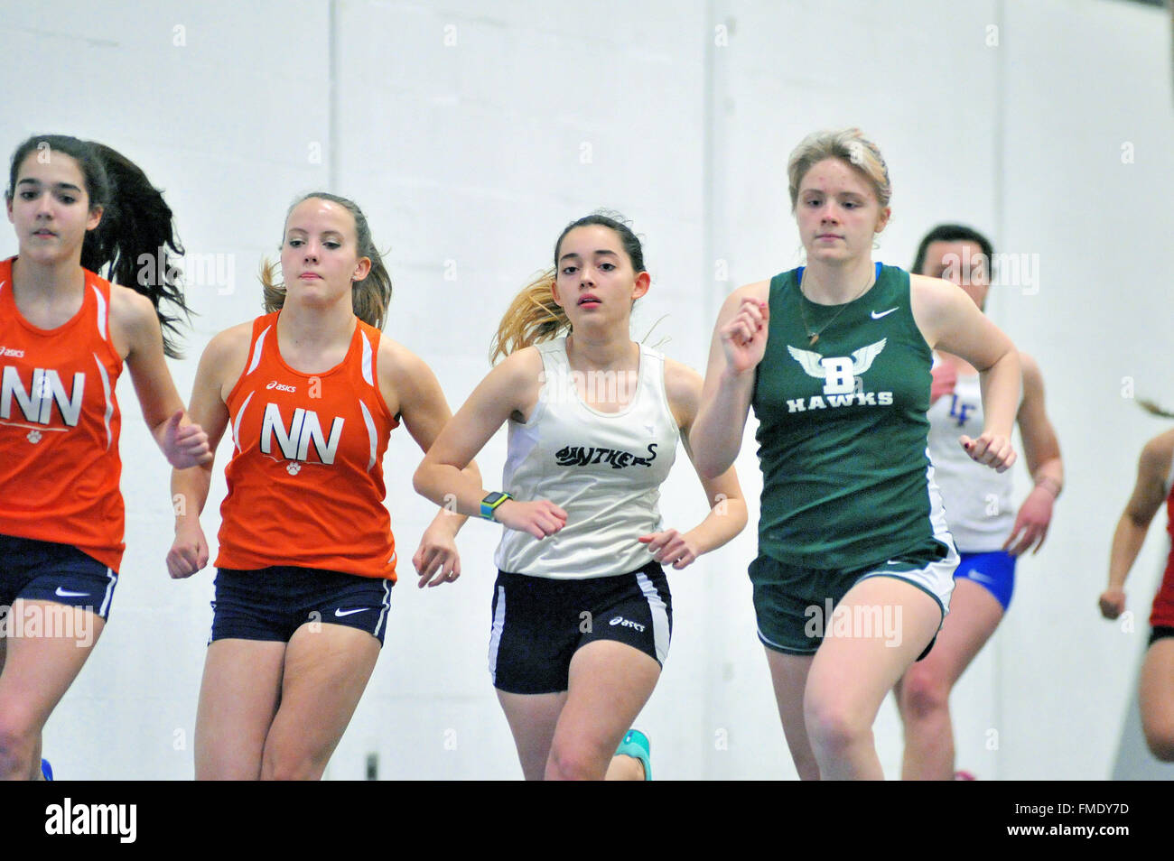 Group of runners respond to the starter's gun as they begin the 3200-meter run during an indoor high school meet. USA. Stock Photo
