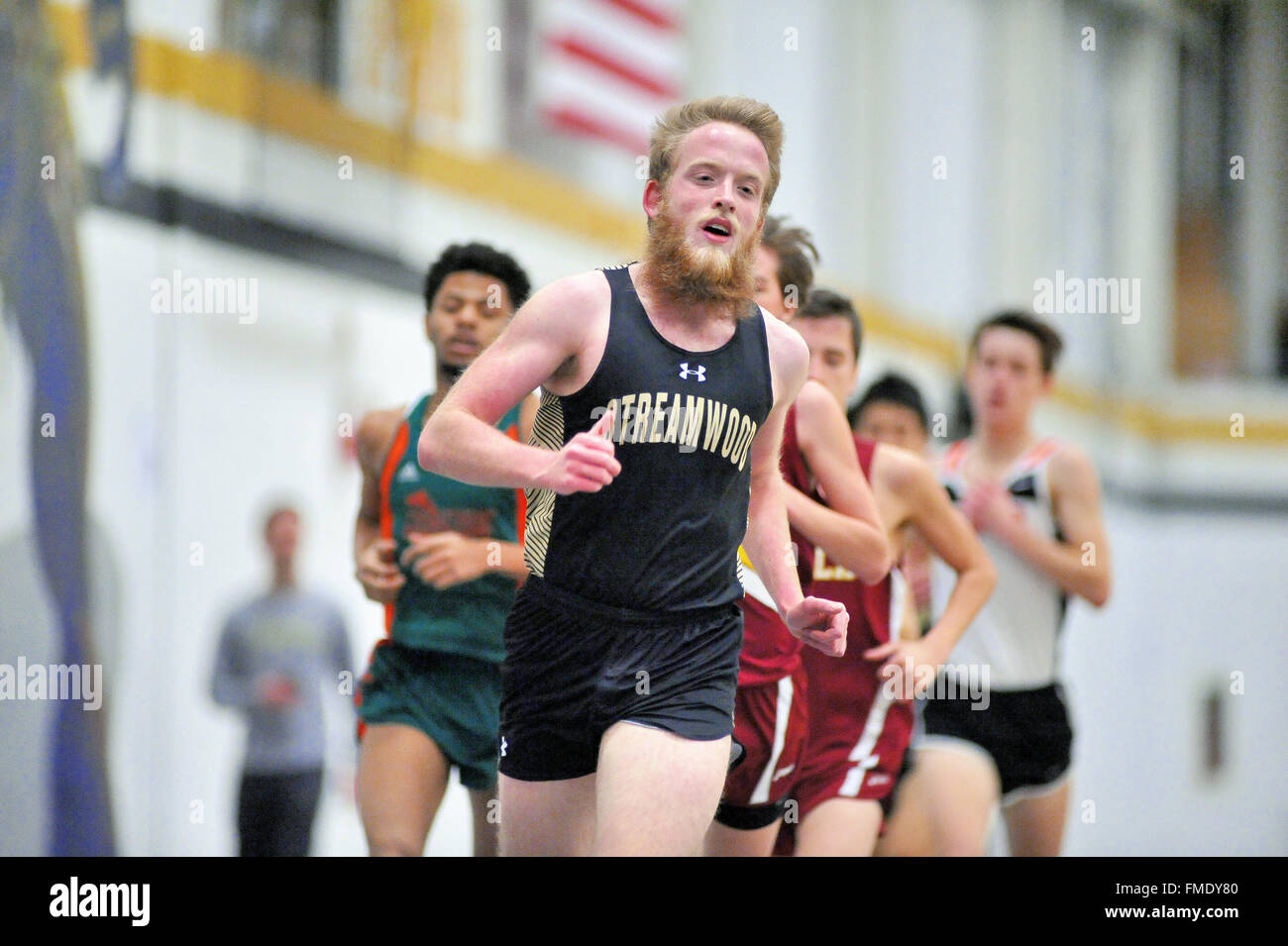 Runner leading the pack during the 3200-meter run at an indoor high school track meet. USA. Stock Photo