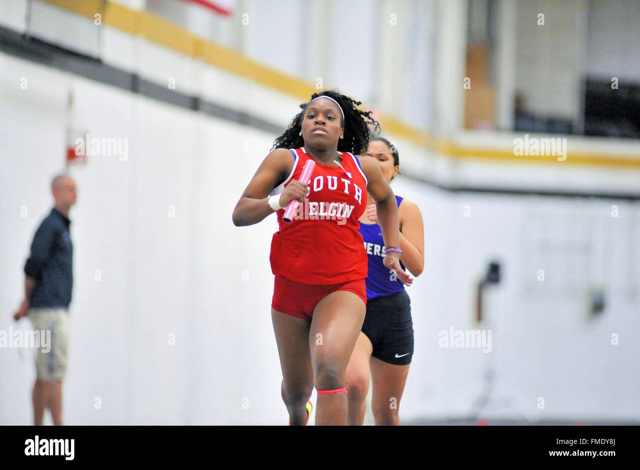 A high school runner completing a leg of 4x160meter relay event during