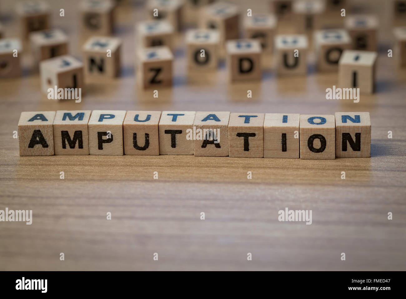 Amputation written in wooden cubes on a table Stock Photo