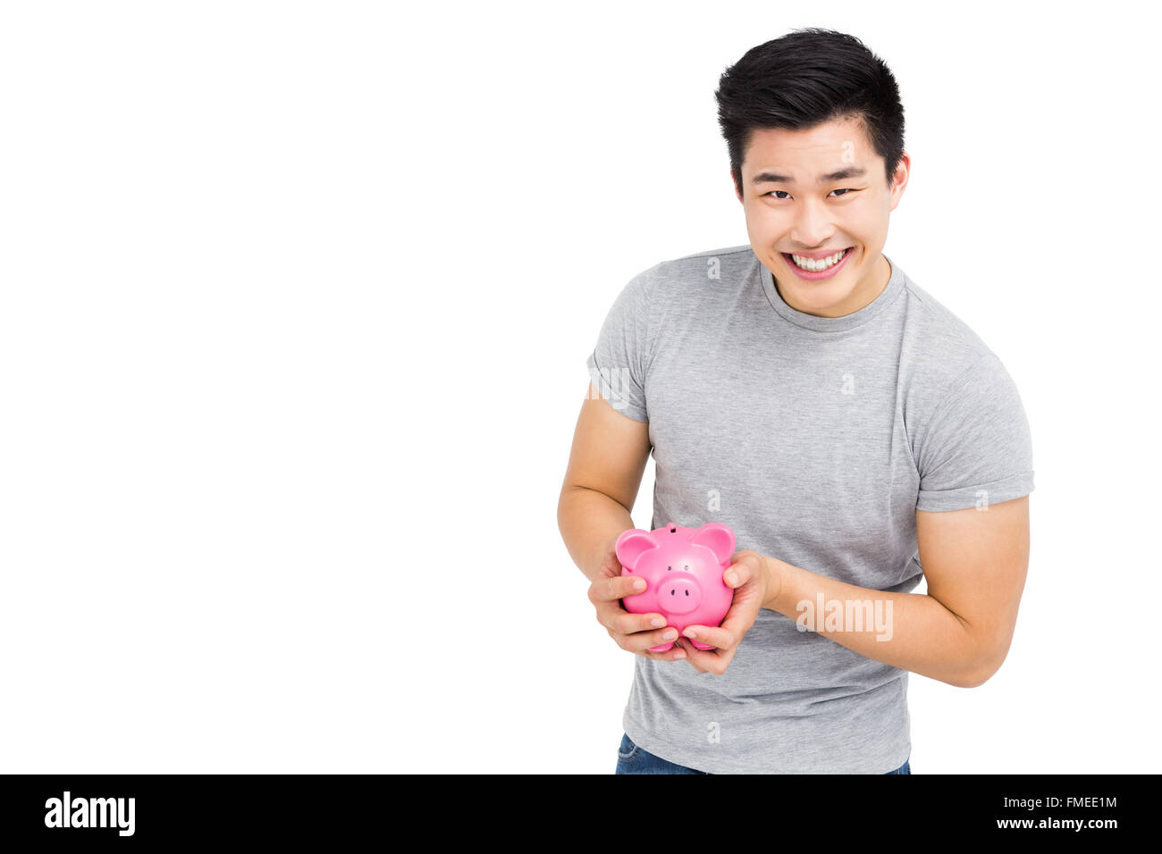 Young man holding a piggy bank Stock Photo - Alamy