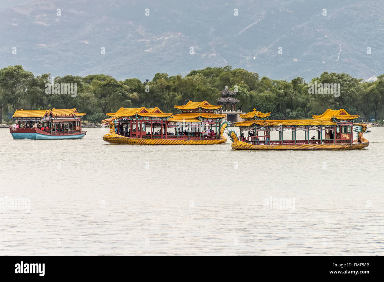People enjoy a dragon boat traveling on the Kunming Lake, Beijing, China on a smoggy day. Stock Photo