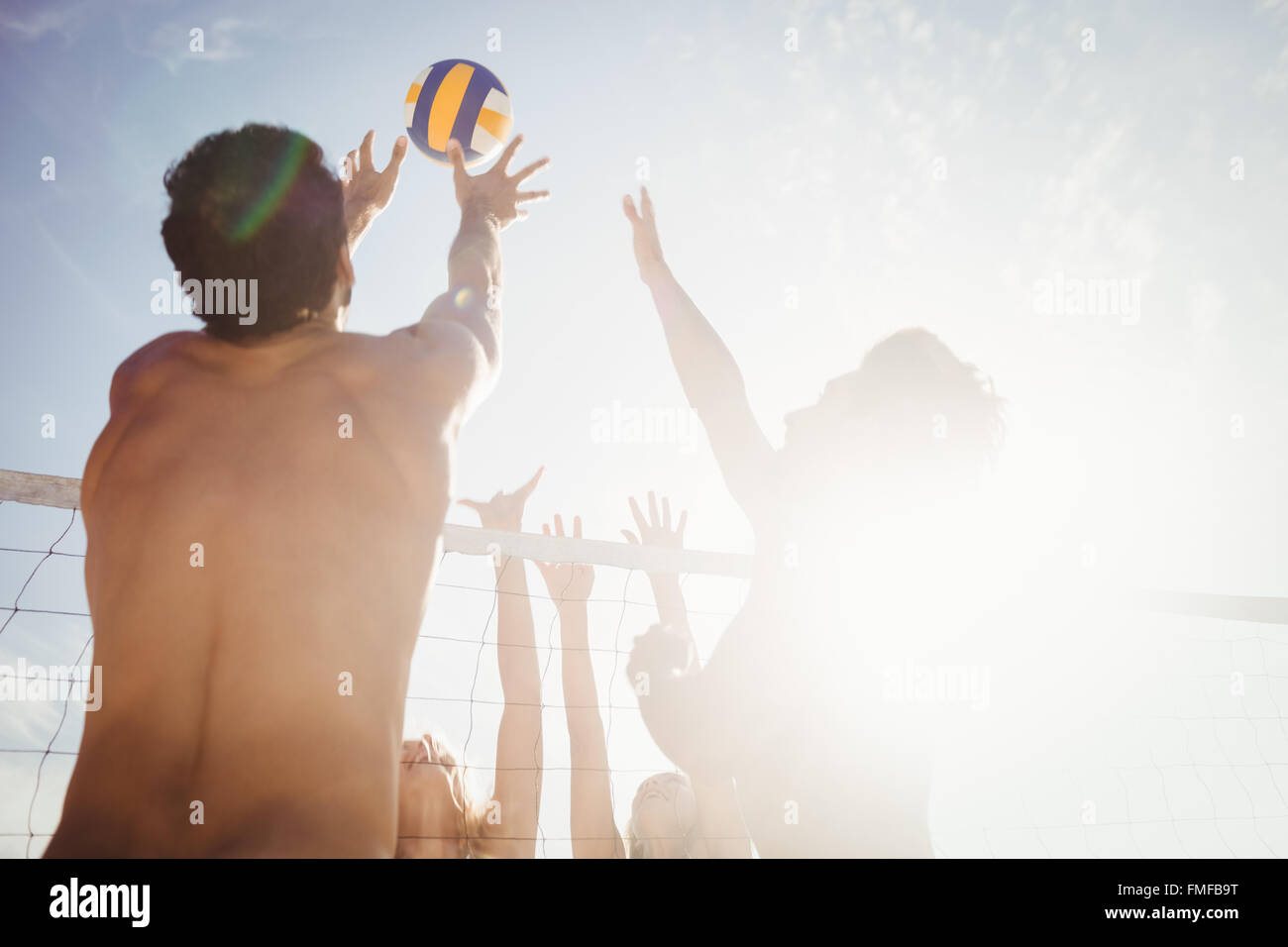 Friends playing beach volleyball Stock Photo