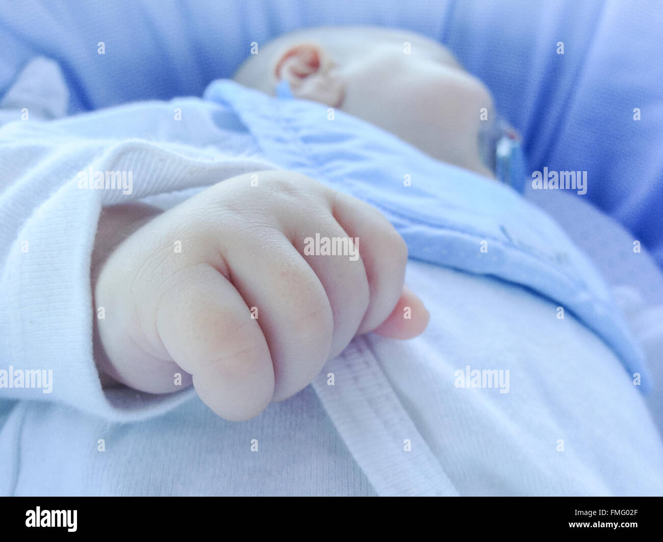 Detail of hand at sleeping four month baby boy. He is lying in carrycot
