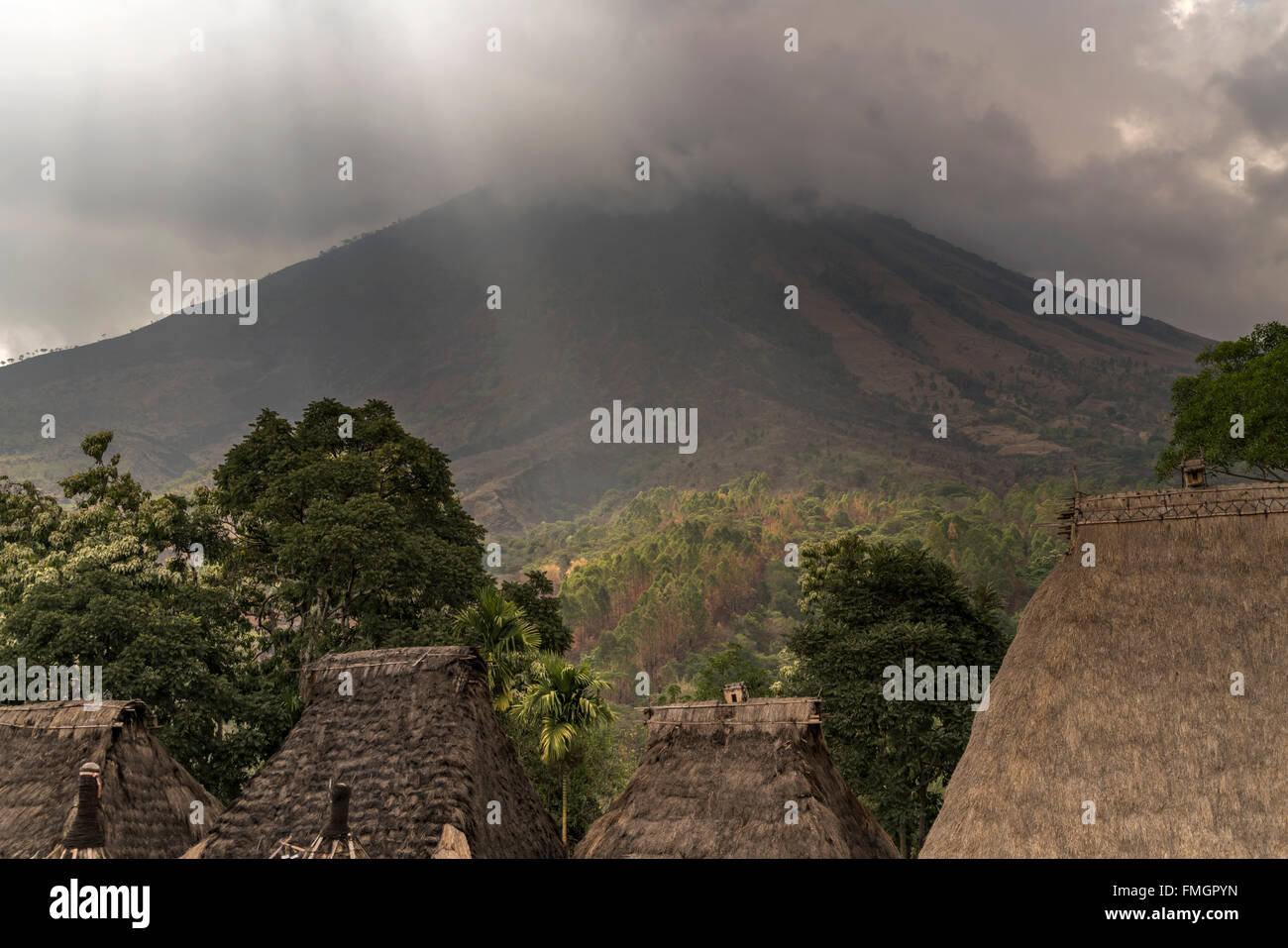 Inerie Volcano and traditional high thatch-roofed houses in the Ngada village Bena near Bajawa, Flores, Indonesia, Asia Stock Photo