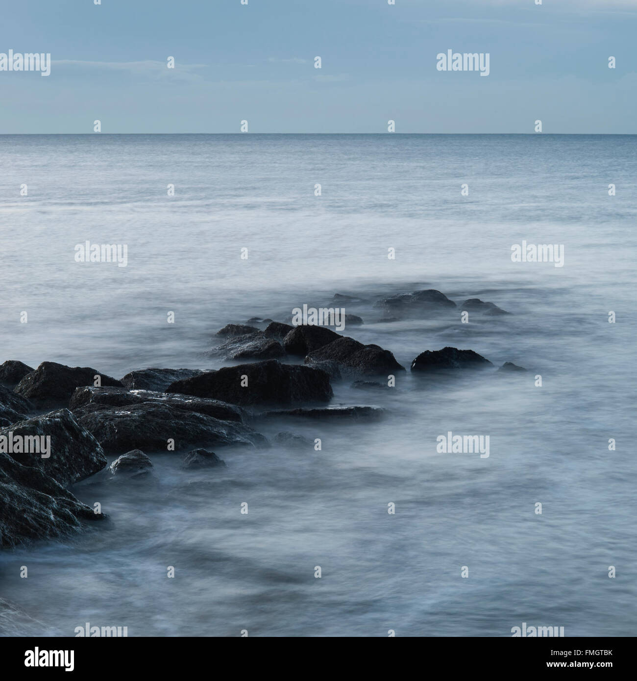 Beautiful sunrise landscape over rocks in sea Stock Photo - Alamy