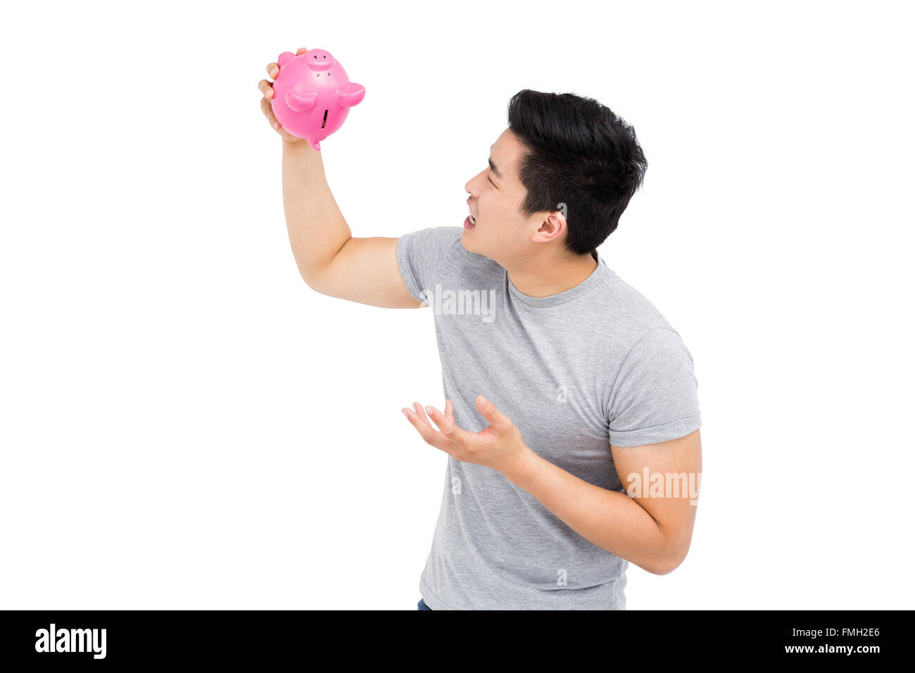 Young man holding a piggy bank Stock Photo - Alamy