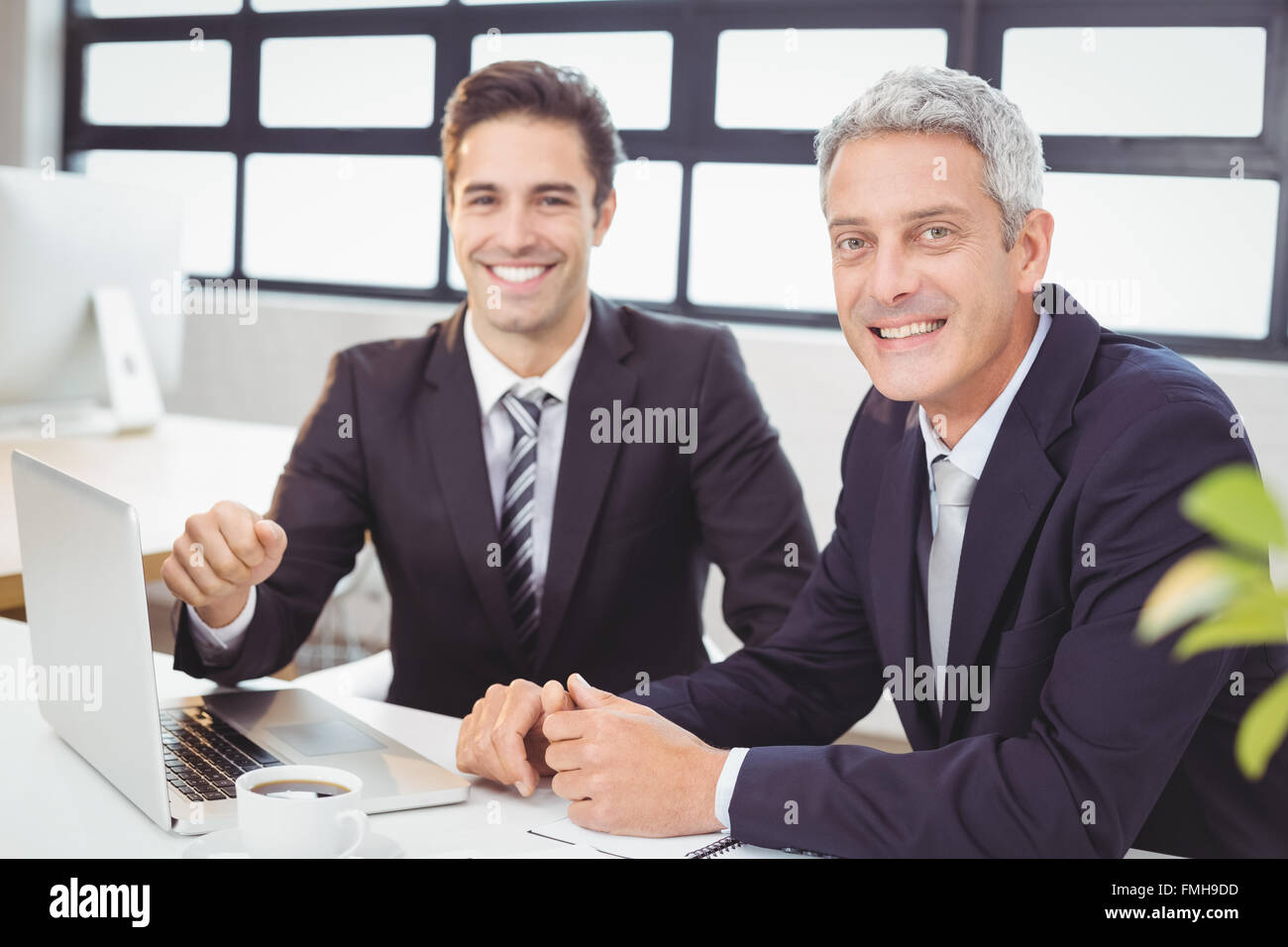Portrait of smiling business people with laptop Stock Photo - Alamy