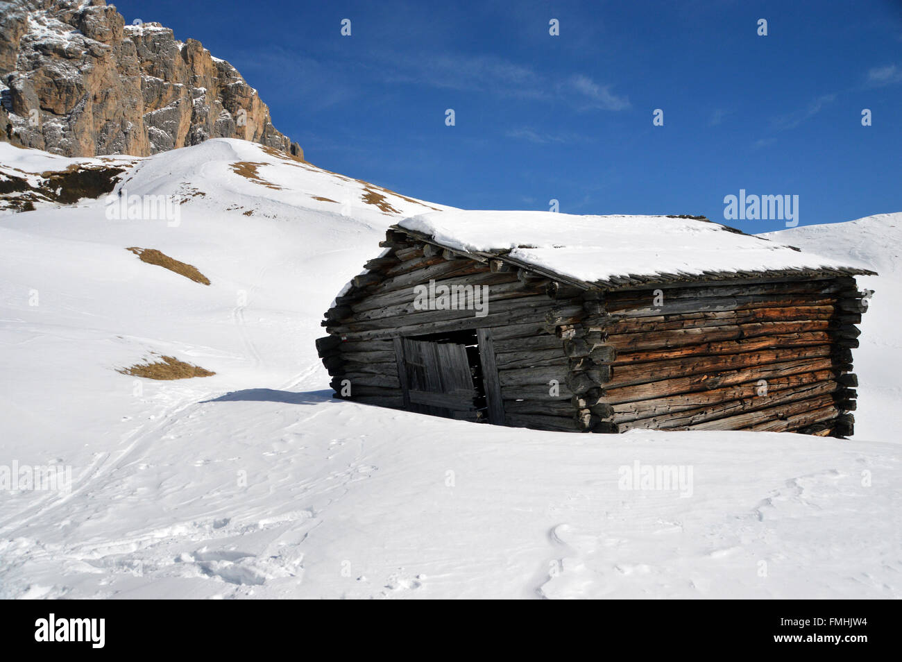Old Leaning Traditional Alpine Hut in Snow Filled Meadow in Corvara Italian Dolomites Stock Photo