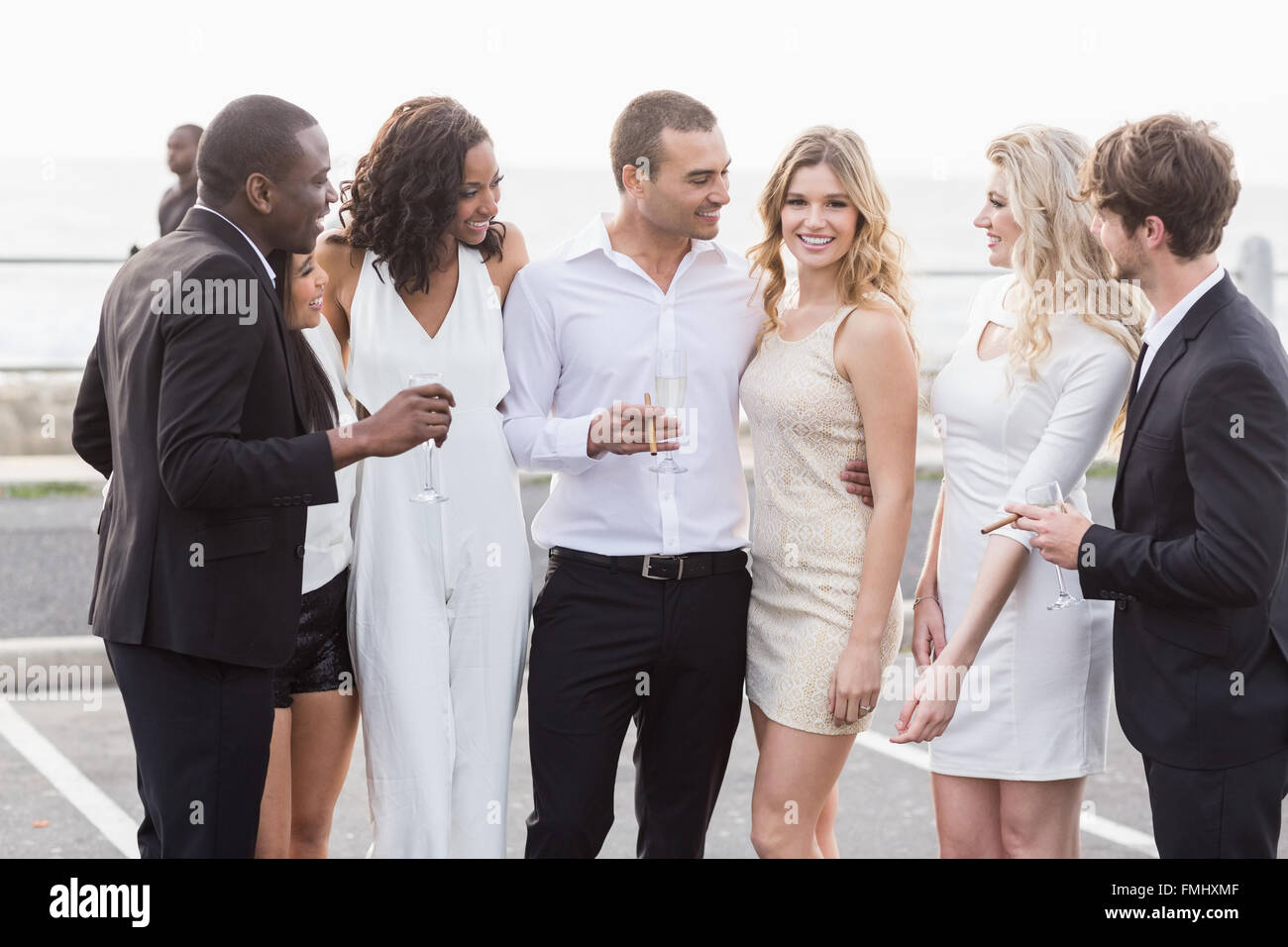 Well dressed people posing next to a limousine Stock Photo
