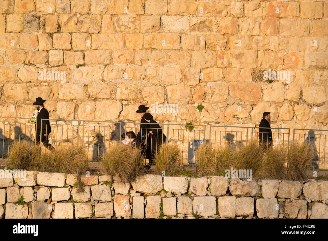 Jews walking along the Old City walls. Jerusalem Old City. Israel. Stock Photo