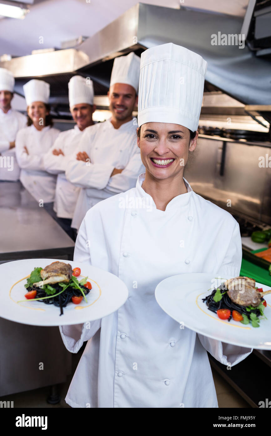 Team of chefs with one presenting dishes Stock Photo Alamy