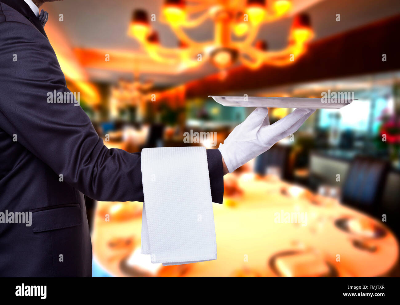 Waiter holding a tray at a luxury restaurant Stock Photo - Alamy