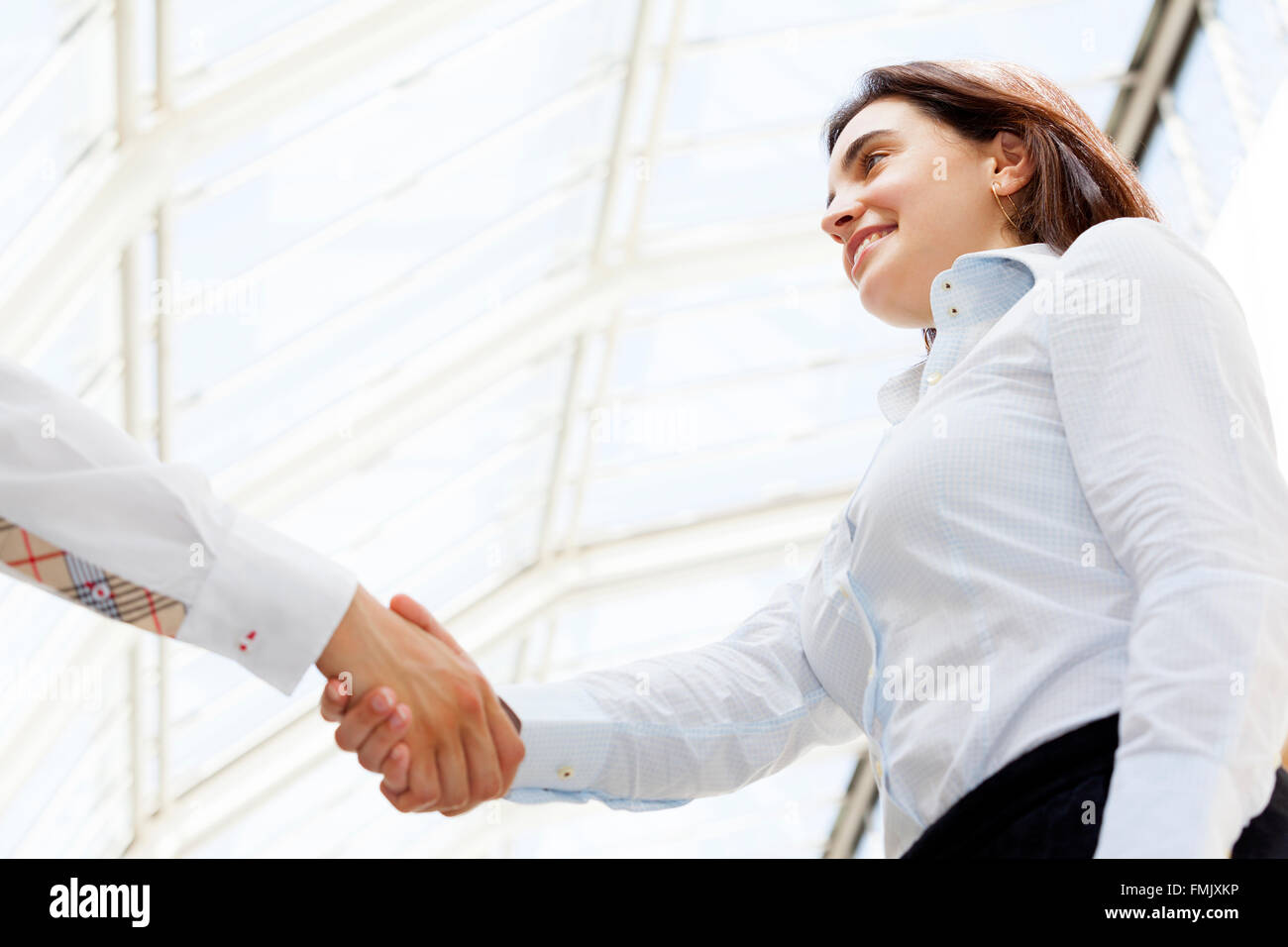 Smiling businesswoman giving a handshake Stock Photo - Alamy