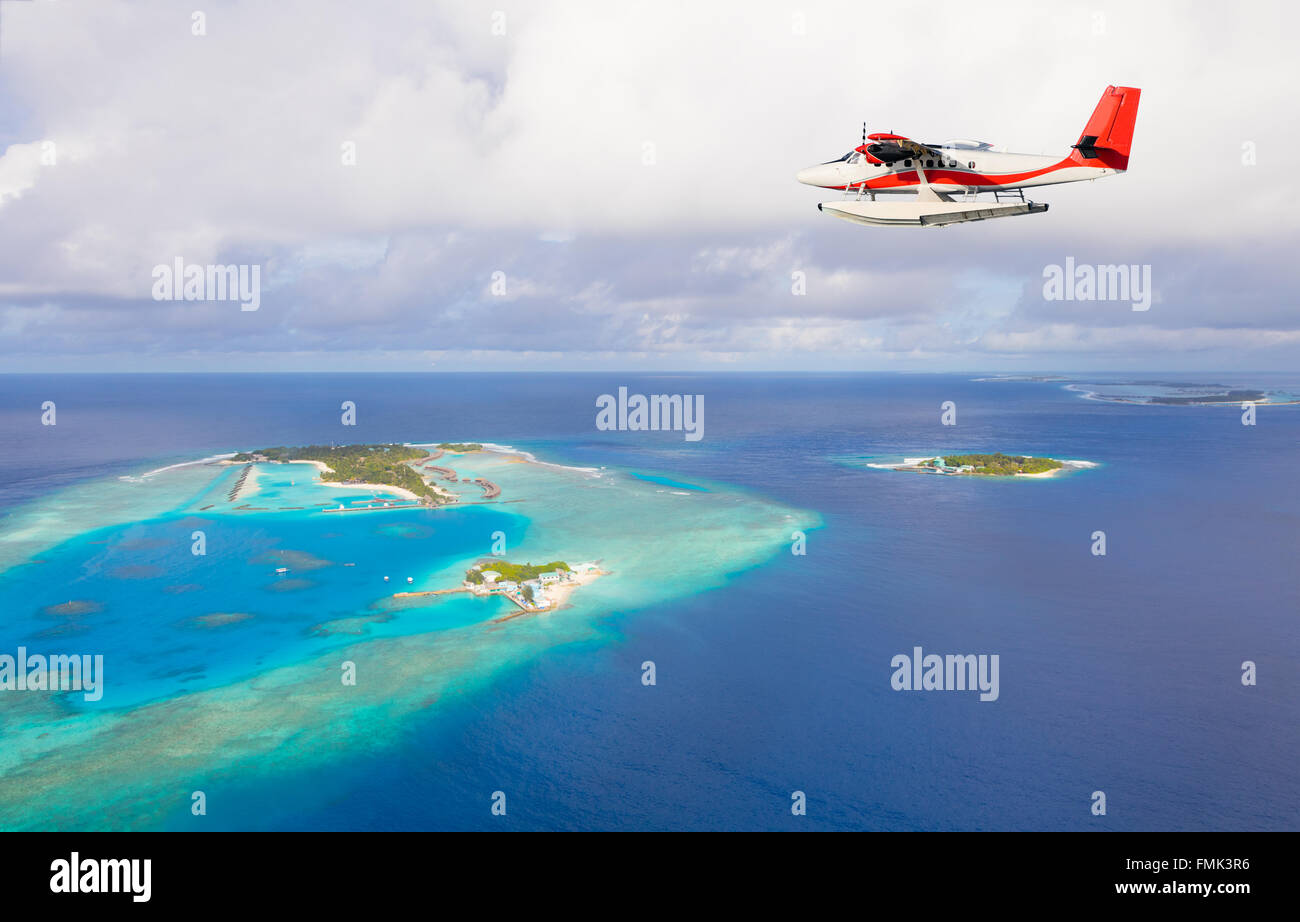 Sea plane flying above Maldives islands Stock Photo