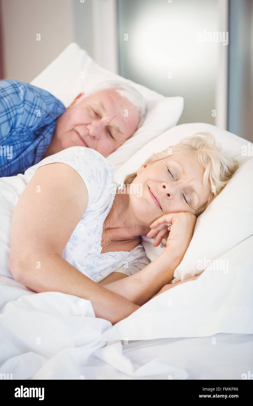 Smiling senior woman sleeping besides husband on bed Stock Photo Alamy
