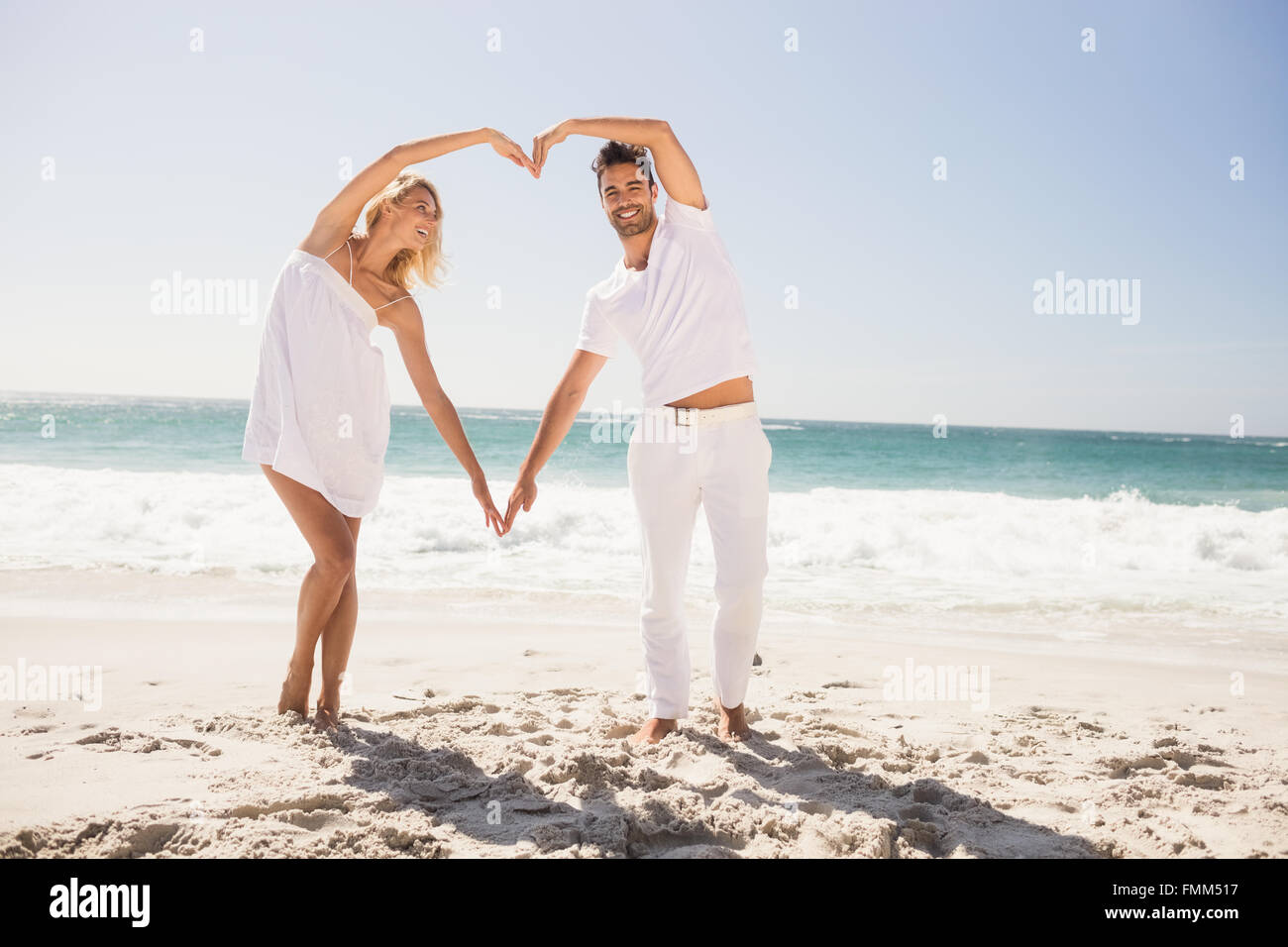 Smiling young couple doing heart shape Stock Photo - Alamy