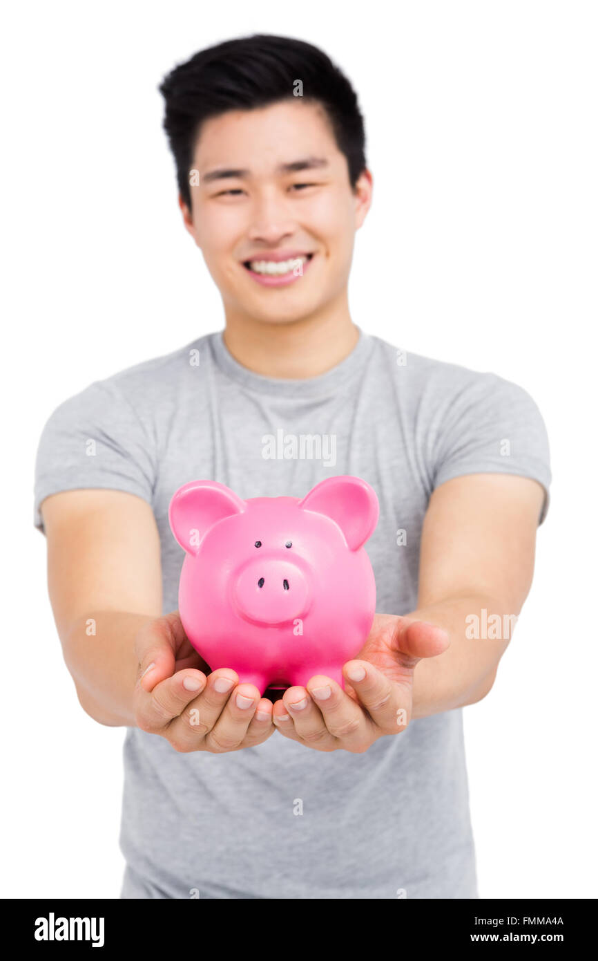 Young man holding a piggy bank Stock Photo - Alamy