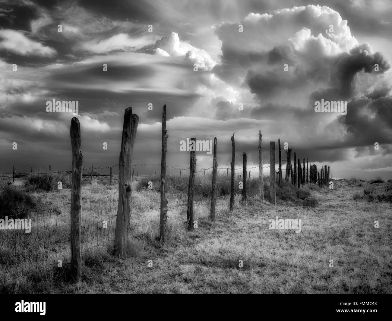 Fence line and thunderstorm clouds near Coal Mine Canyon, Arizona Stock Photo