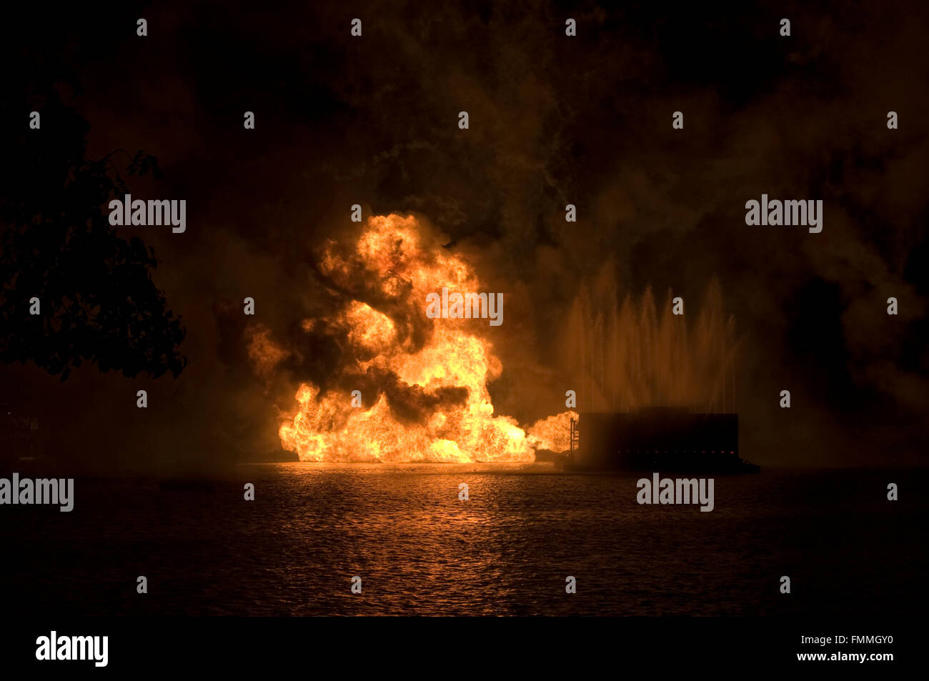 Gas fire explosion on water at night Stock Photo