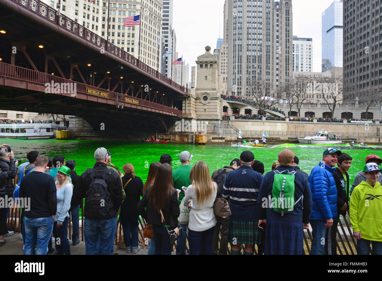 People watch from the bank as the Plumbers Union dyes the Chicago River green for St. Patrick's Day on March 12, 2016. Stock Photo