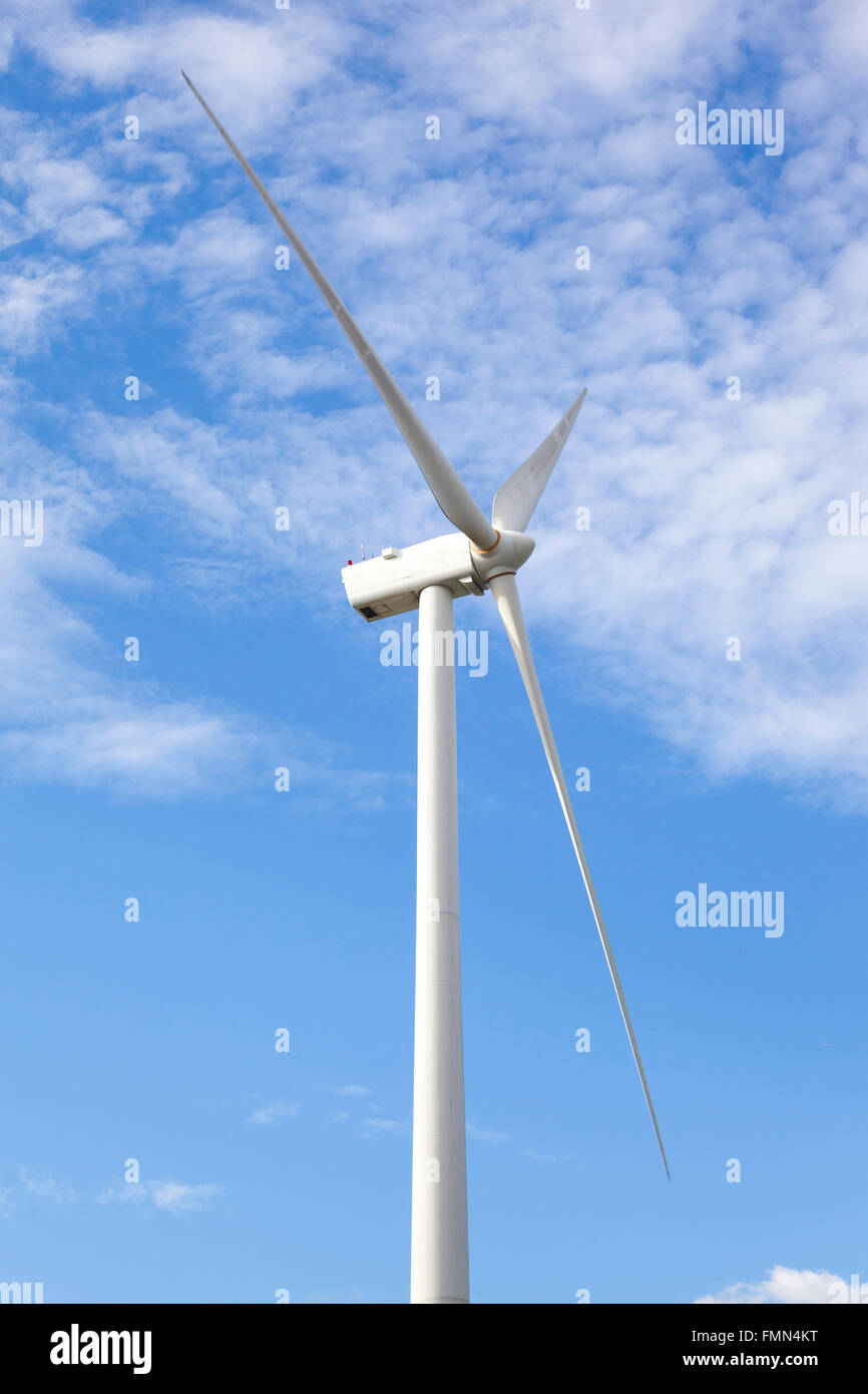 Wind turbine against cloudy blue sky Stock Photo - Alamy
