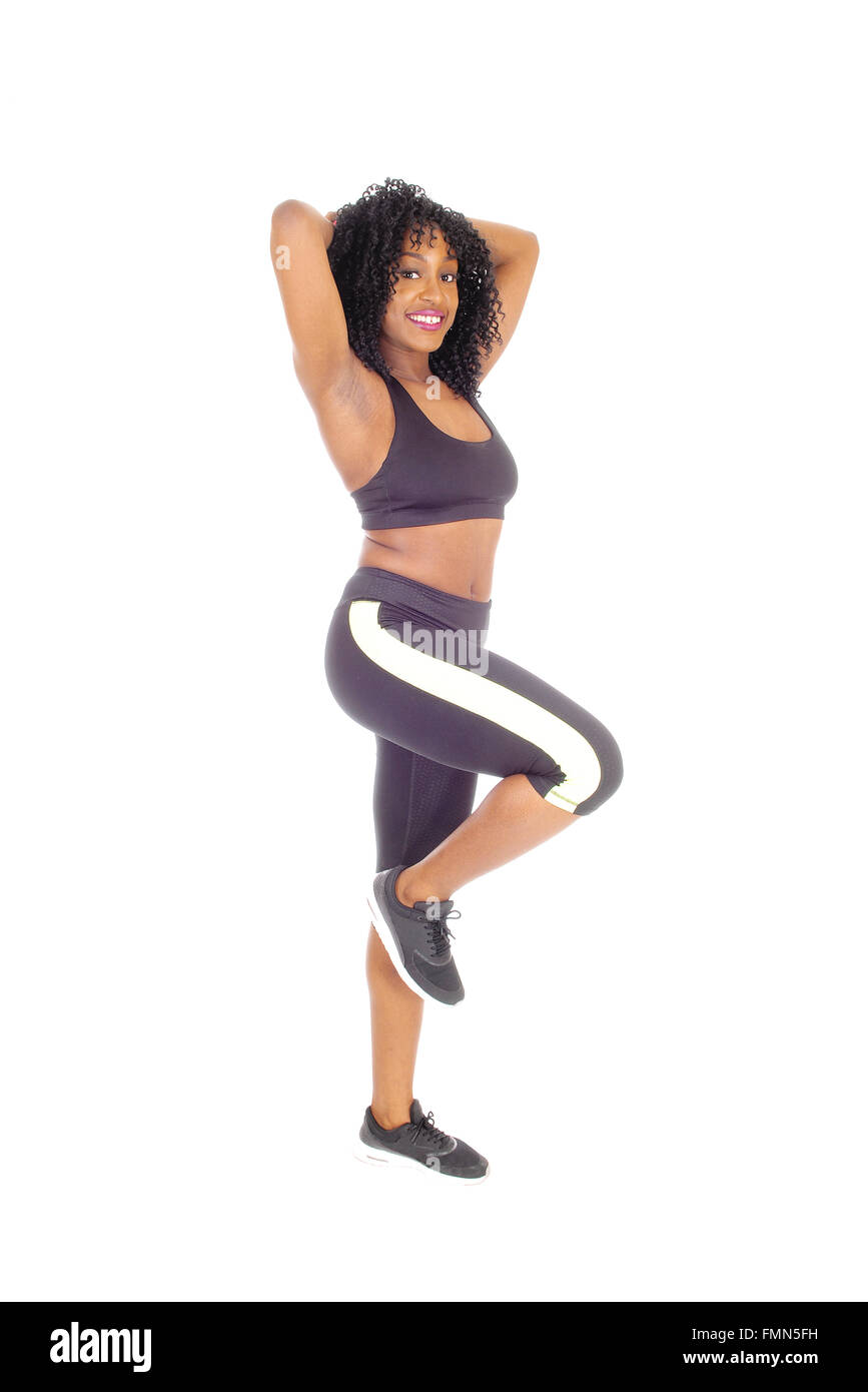 A slime African American woman in black exercise clothing standing in  profile, showing her great figure, isolated for white back Stock Photo -  Alamy
