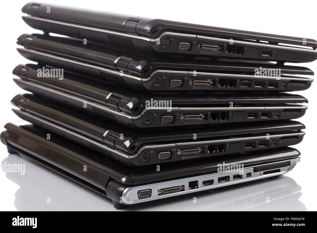 stack of old laptops awaiting repair isolated on white background Stock