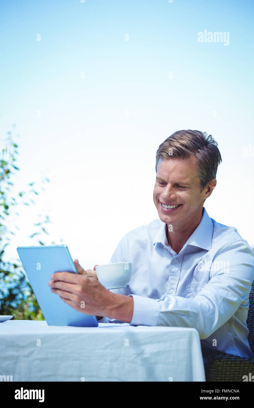 Businessman using tablet with coffee Stock Photo - Alamy