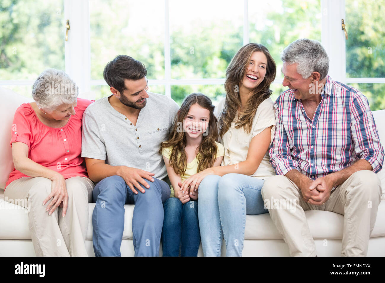 Family sitting on sofa in living room Stock Photo - Alamy