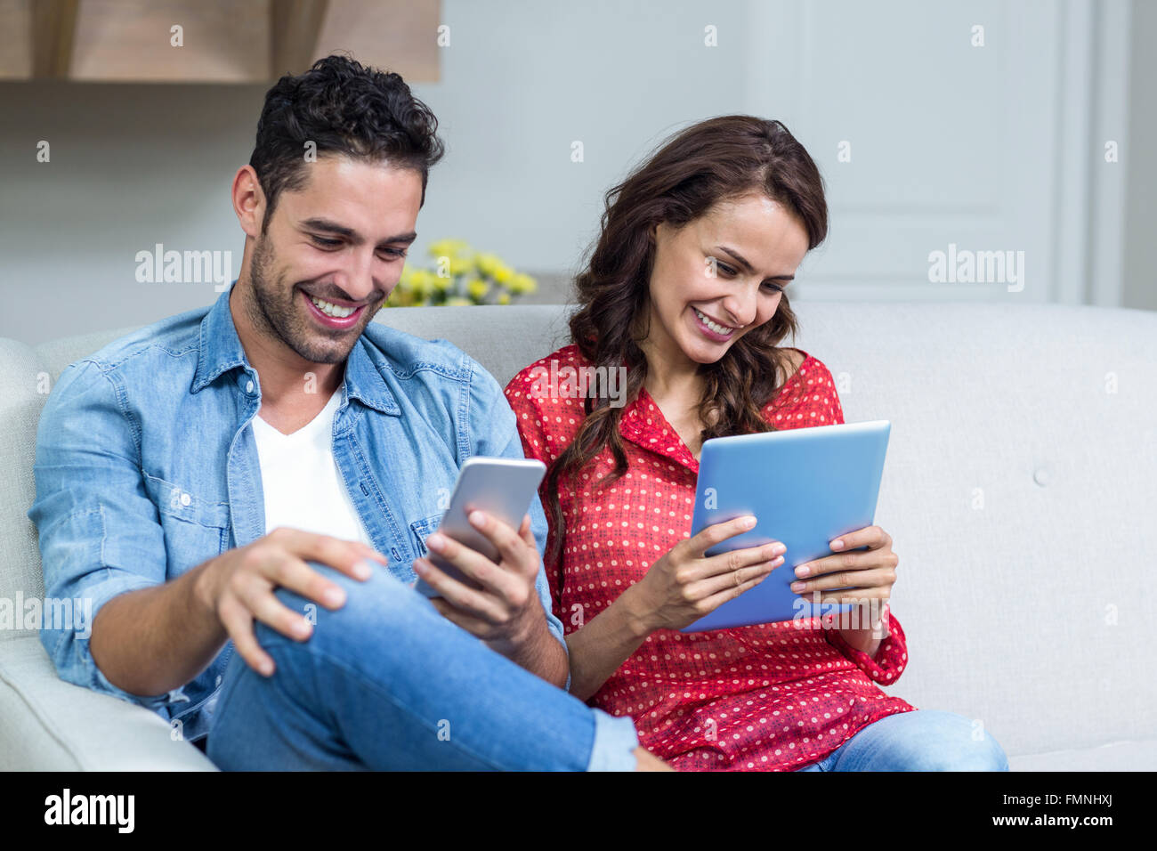 People Smiling While Using Technology Smiling couple using technology Stock Photo - Alamy