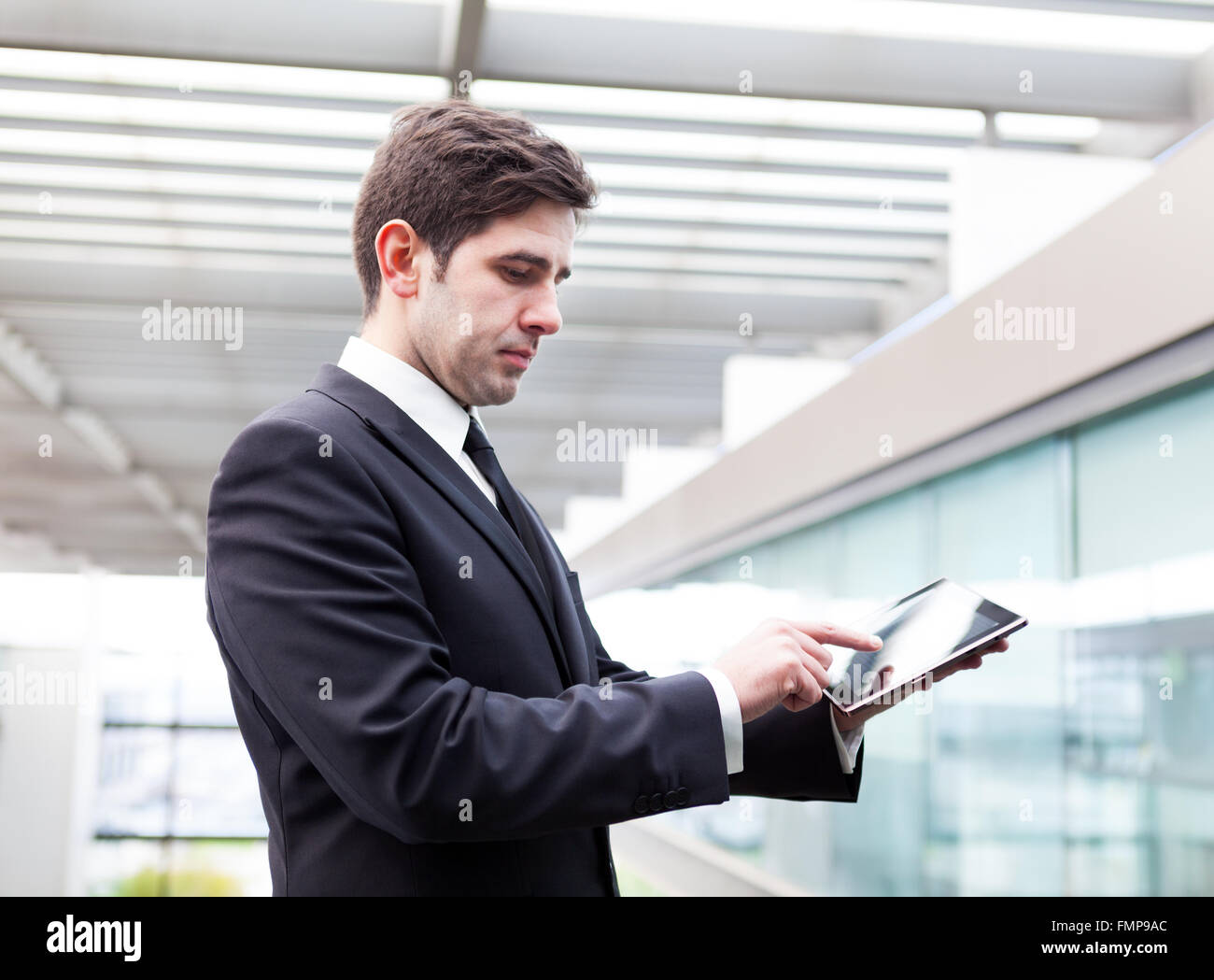 Young businessman using his digital tablet at the office Stock Photo ...