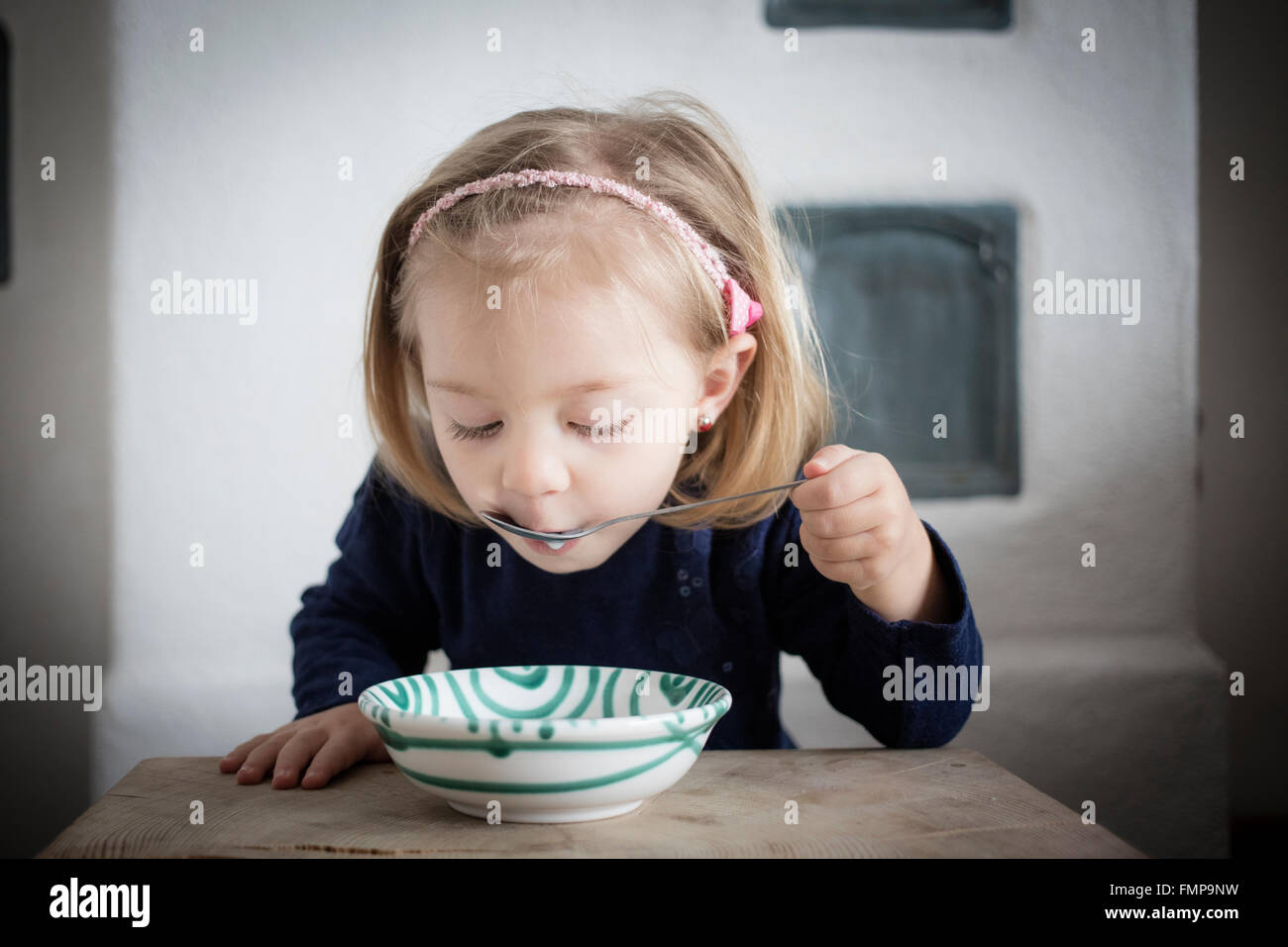 Little girl eating cereal from a bowl, Upper Bavaria, Germany Stock