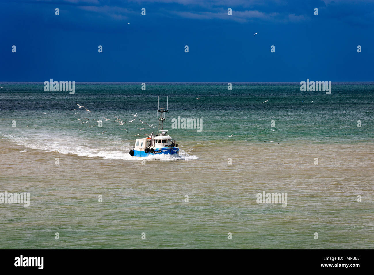 Fishing boat in the sea in front of storm front in Saint-Valery-en-Caux, Département Seine-Maritime, Normandy, France Stock Photo