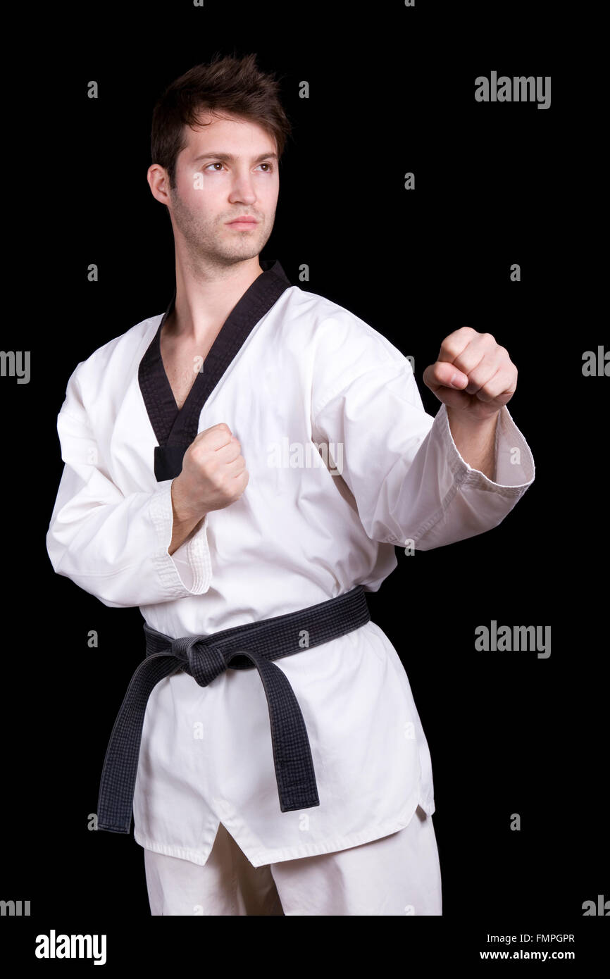 Young man practicing martial arts over black background Stock Photo - Alamy