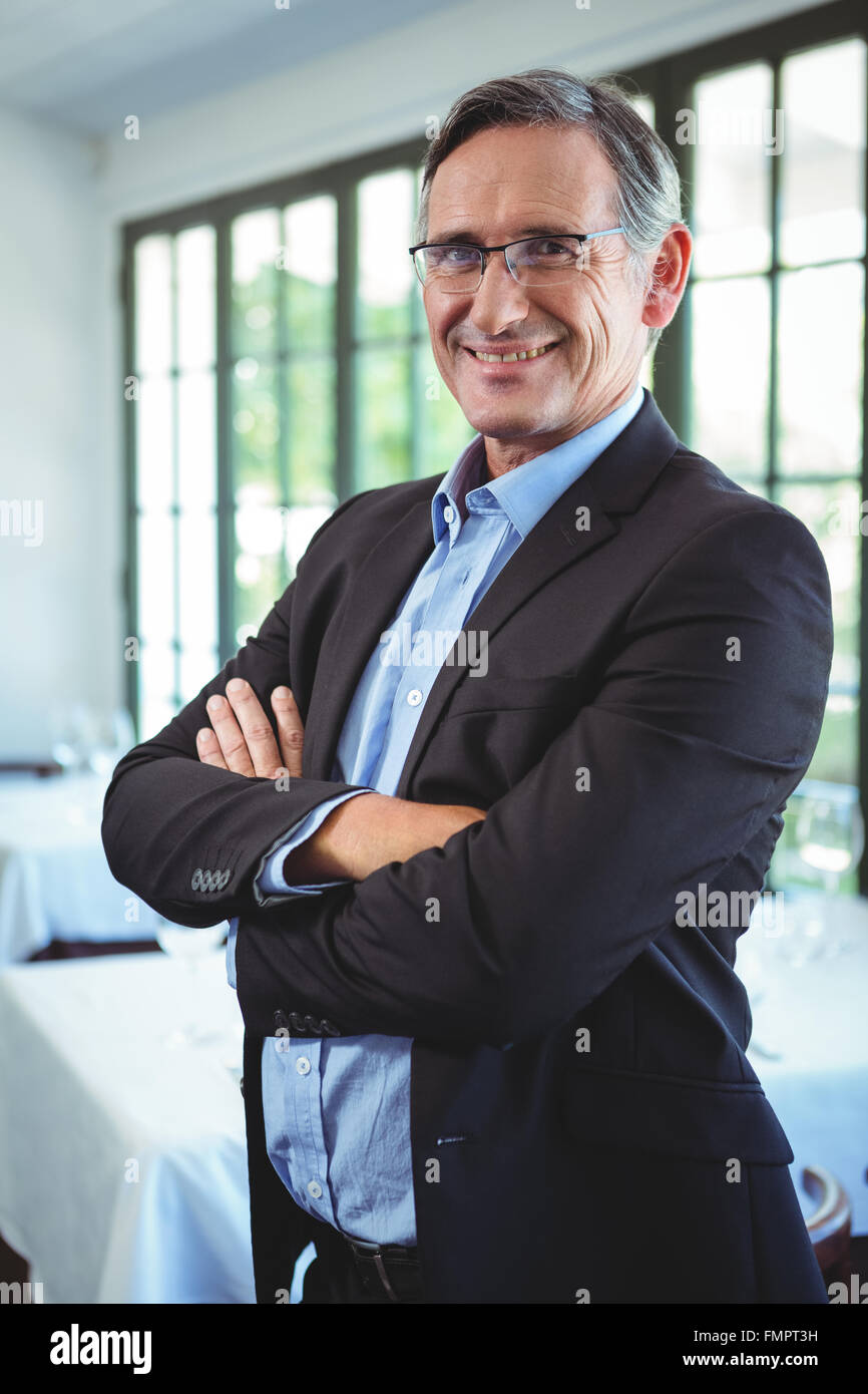 Smiling businessman posing with crossed arms Stock Photo - Alamy