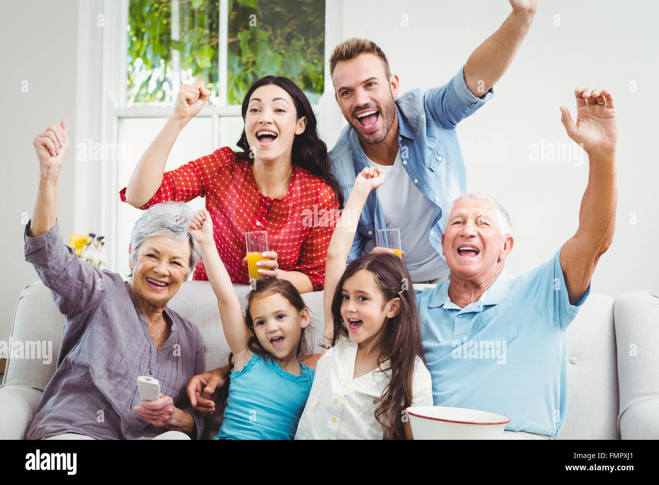 Family cheering while watching television Stock Photo - Alamy