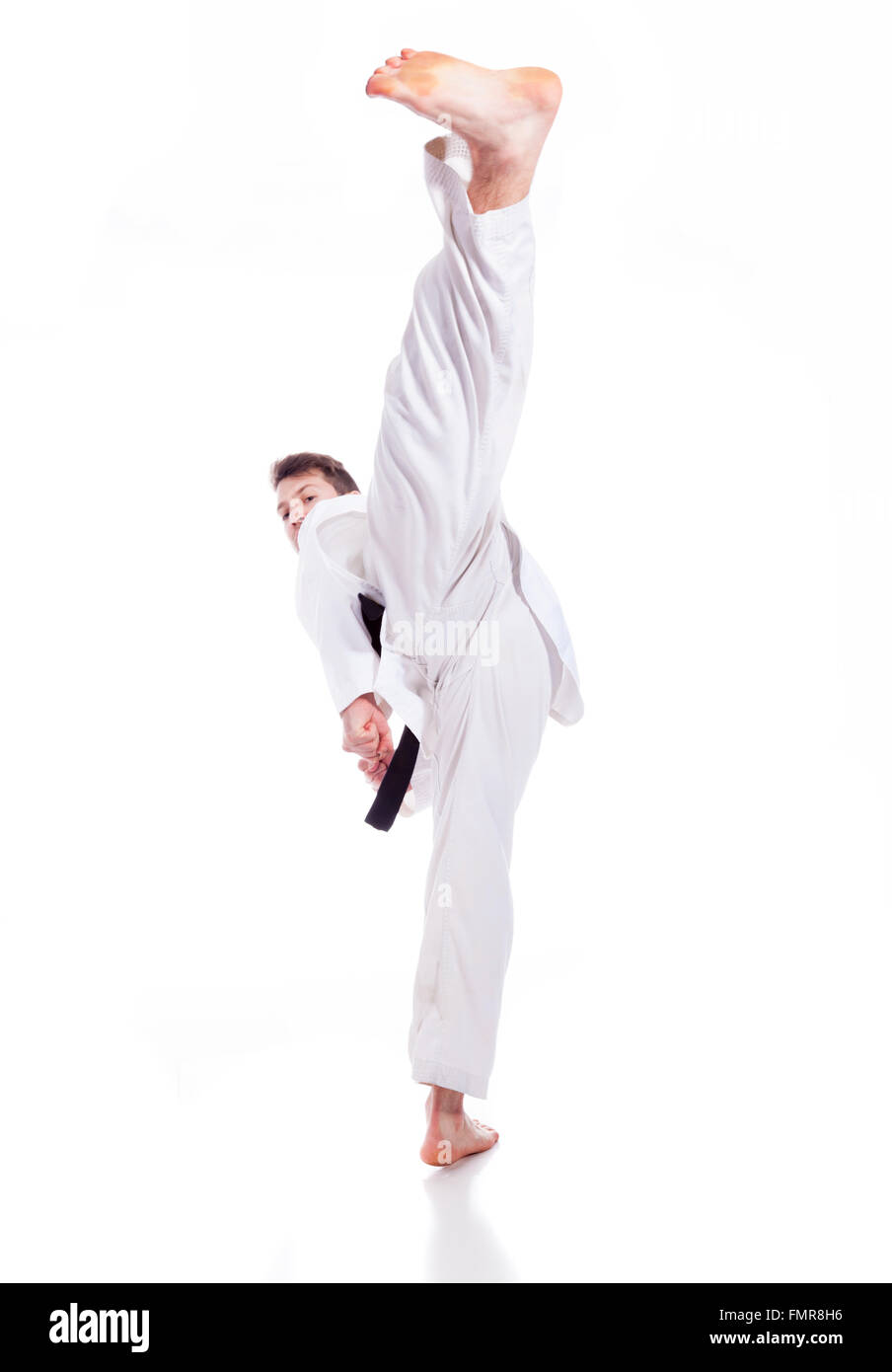 Young man practicing martial arts over white background Stock Photo