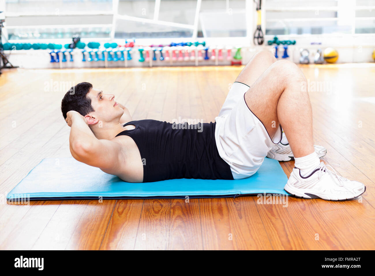 Handsome man exercising abdominal muscles at the gym Stock Photo