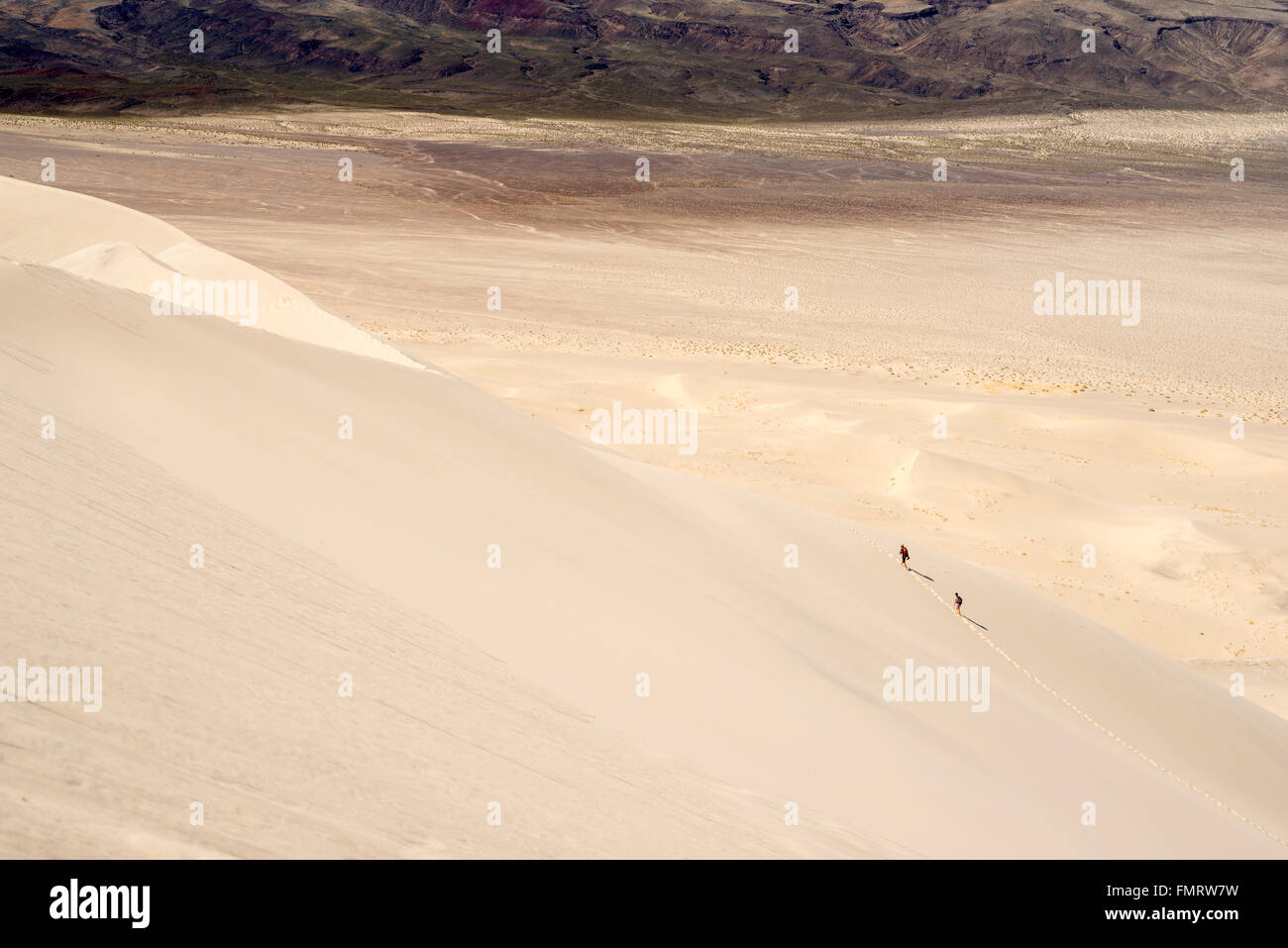 Two people hiking on the Eureka Valley sand dunes in Death Valley ...