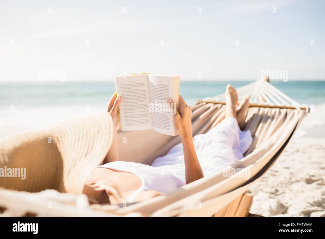 Woman reading book in hammock Stock Photo - Alamy