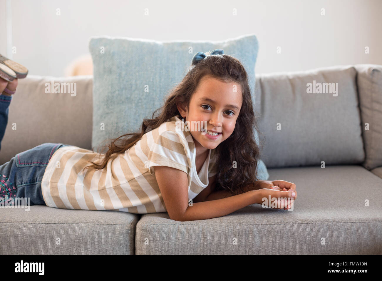 Portrait of a girl lying on sofa Stock Photo - Alamy
