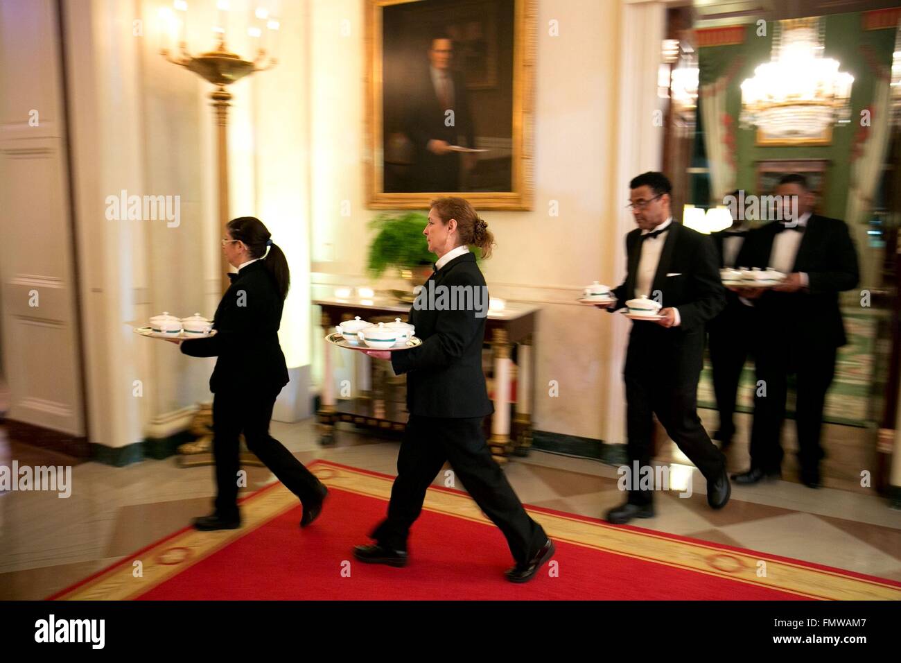 The White House wait staff carries dinner to guest during the State Dinner in honor of Canadian Prime Minister Justin Trudeau in the East Room of the White House March 10, 2016 in Washington, DC. This is the first state visit by a Canadian Prime Minister in 20-years. Stock Photo