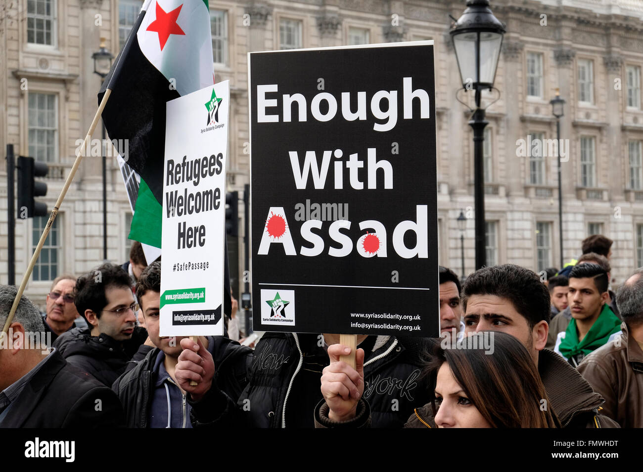 Syrians protesters holding a placard reading "enough with Assad" Stock Photo